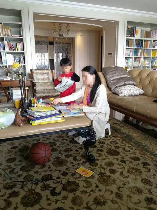 朱小貞和小兒子在客廳里，背后書架為起火點(diǎn)。（受訪者供圖）